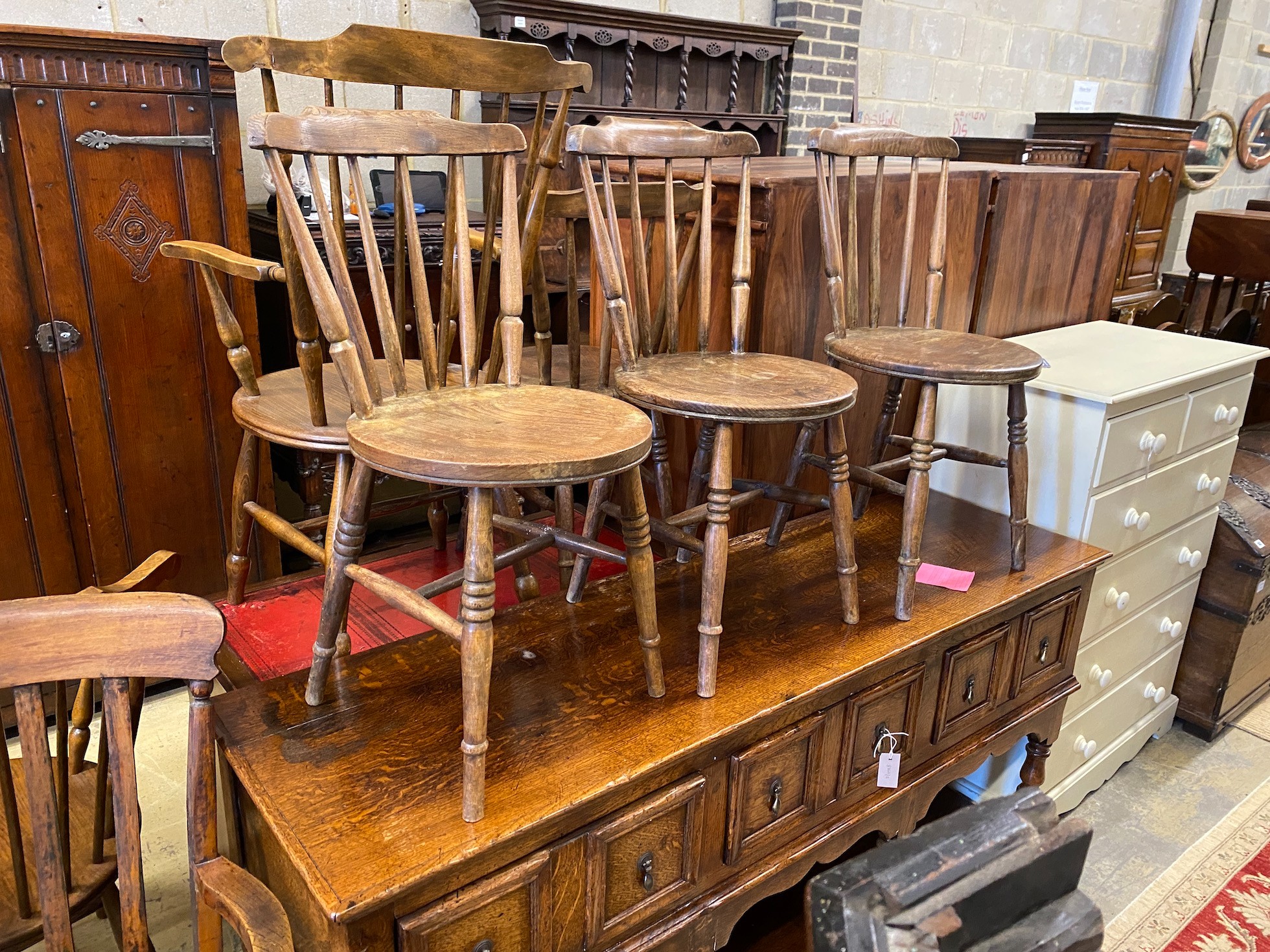 An early 20th century harlequin set of six Windsor elm and beech dining chairs, two with arms